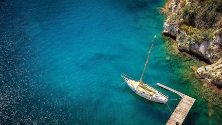 Serene Waters Embracing a Solitary Sailboat wallpaper