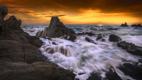 Serene Sunset Over Rocky Shoreline wallpaper