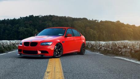 Sleek Red BMW on a Scenic Roadway wallpaper