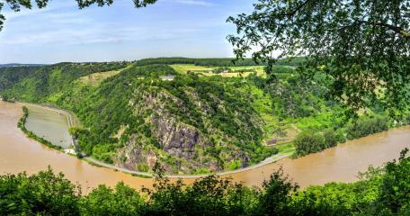 Serene River Valley Surrounded by Lush Greenery wallpaper