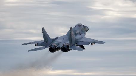 Fighter Jet in Majestic Flight Over Clouds wallpaper