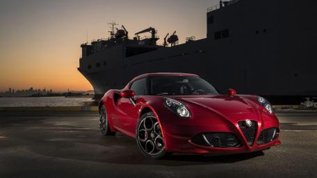 Sleek Red Sports Car Against Sunset Backdrop wallpaper