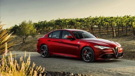 Sleek Red Car Amidst Scenic Vineyard Landscape wallpaper
