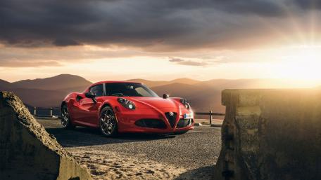 Stunning Red Sports Car Against a Sunset Background wallpaper