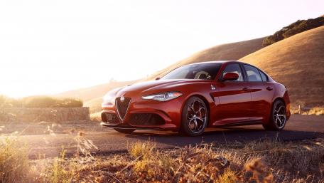 Sleek Red Car Against Scenic Landscape wallpaper
