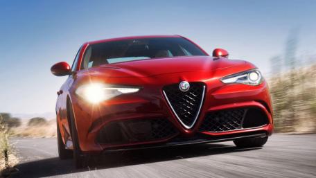 Sleek Red Car Racing Down Open Road wallpaper