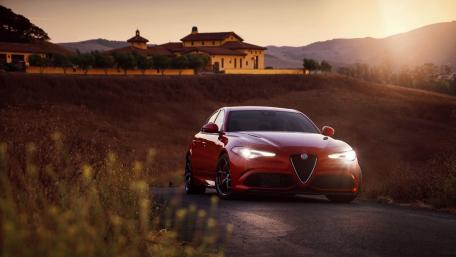 Elegant Car Amidst a Sunset Landscape wallpaper