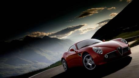 Red Sports Car on a Scenic Roadway wallpaper