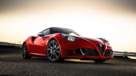 Sleek Red Sports Car Under Sunset Glow wallpaper
