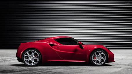 Sleek Red Sports Car Against Industrial Background wallpaper