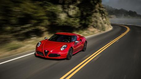 Red Alfa Romeo on Scenic Curved Road Driving Fast in Nature wallpaper