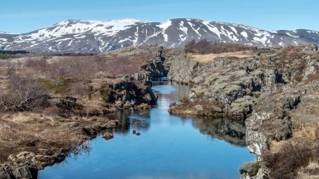 Serene River Flowing Through Majestic Mountains wallpaper