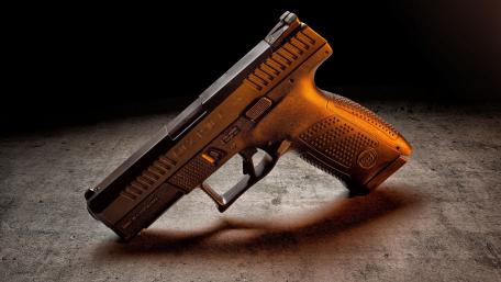 Sleek Military Pistol on Concrete Surface wallpaper