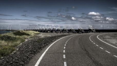 Tractors Aligned on Scenic Coastal Road wallpaper