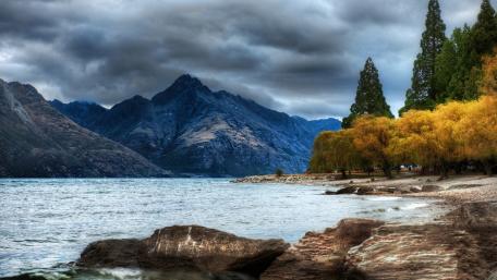 Serene Lakeside Landscape with Majestic Mountains and Autumn Trees wallpaper