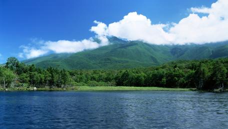 Serene Lake Surrounded by Majestic Mountains and Lush Greenery wallpaper