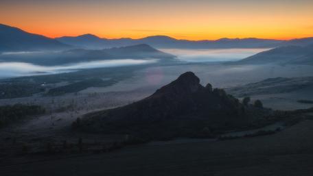 Serene Sunrise Over Misty Mountains wallpaper