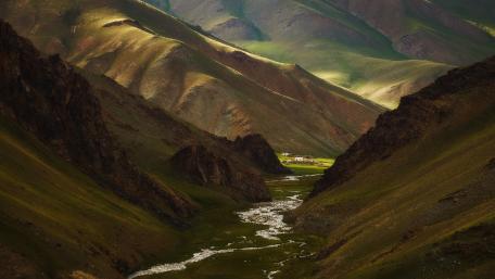 Serene Valley Amidst Majestic Mountains wallpaper
