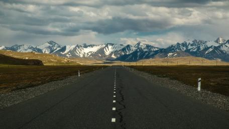 Majestic Road Through Serene Mountain Landscape wallpaper