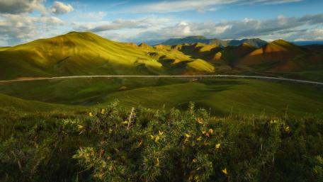 Breathtaking Rolling Green Hills Under a Bright Sky wallpaper