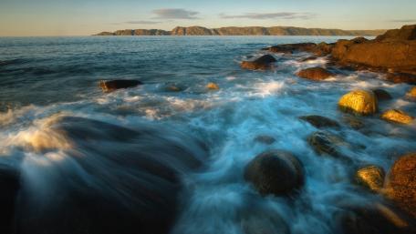 Serene Coastal Waves Dance Among Rocks wallpaper