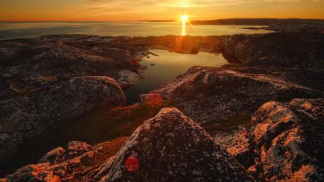 Eternal Sunset Over Rocky Coastline wallpaper
