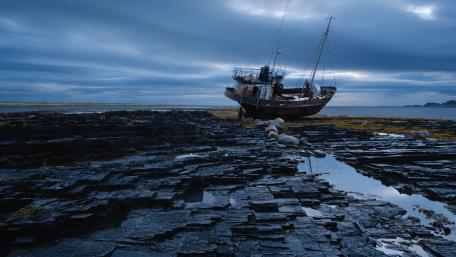 Abandoned Ship Amidst Serene Coastal Landscape wallpaper