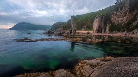 Serene Coastal Landscape with Rocky Outcrops and Calm Waters wallpaper