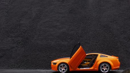 Vibrant Orange Car Against Dark Background wallpaper