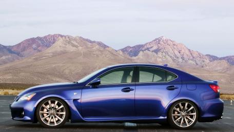 Sleek Blue Car Against Majestic Mountains wallpaper