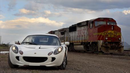 Sleek Sports Car and Majestic Train Encounter wallpaper