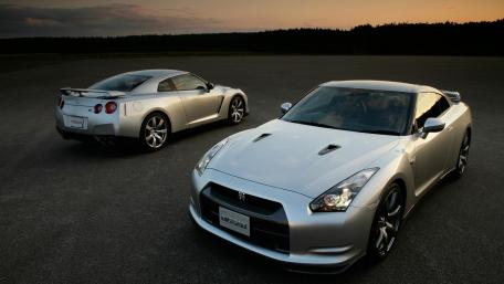 Sleek Silver Performance Cars Under Sunset Sky wallpaper