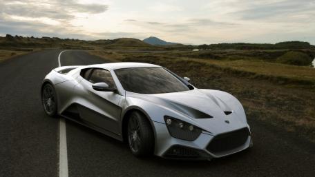 Sleek Silver Supercar on a Scenic Roadway wallpaper