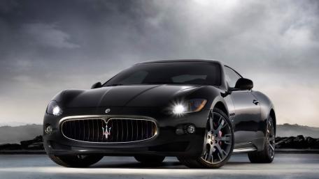 Sleek Black Maserati Under Dramatic Skies wallpaper