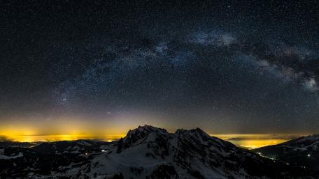 Majestic Milky Way Over Snowy Peaks wallpaper