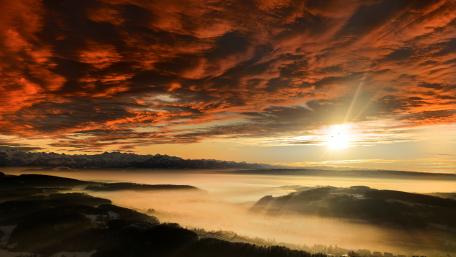 Majestic Sunrise Over Foggy Horizon wallpaper