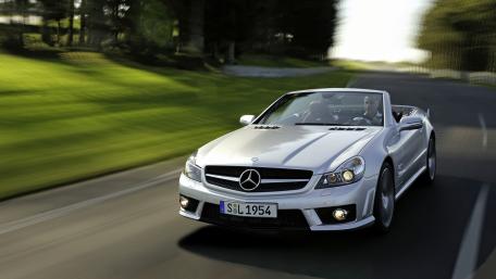 Sleek Mercedes Driving Through Scenic Roadway wallpaper