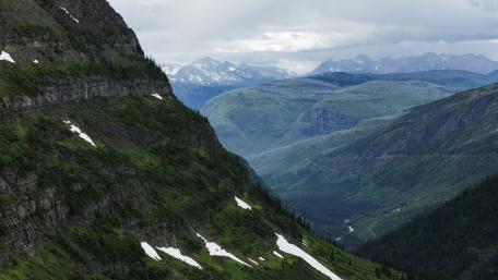 Majestic Mountain Valleys Under Cloudy Skies wallpaper