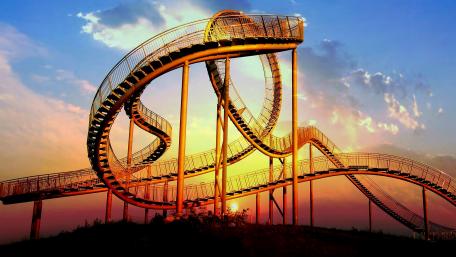 Twisting Roller Coaster Against a Sunset Sky wallpaper