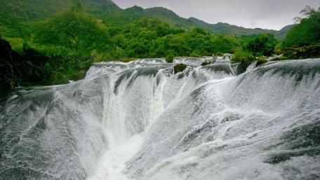 Majestic Waterfall Amidst Lush Greenery wallpaper