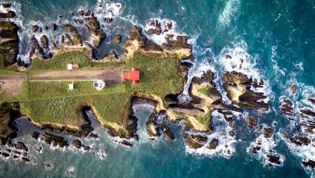 Serene Coastal Lighthouse on Rugged Shoreline wallpaper