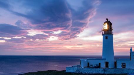 Tranquil Lighthouse at Sunset Over the Ocean wallpaper