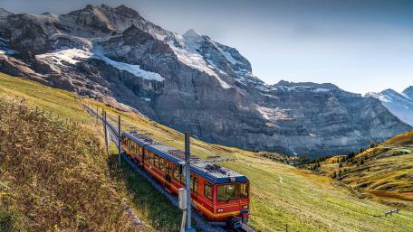 Scenic Train Journey Through Majestic Mountains wallpaper