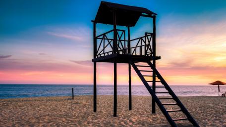 Tranquil Beach Sunset with Lifeguard Tower wallpaper