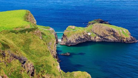 Majestic Green Cliffs Overlooking Serene Blue Waters wallpaper