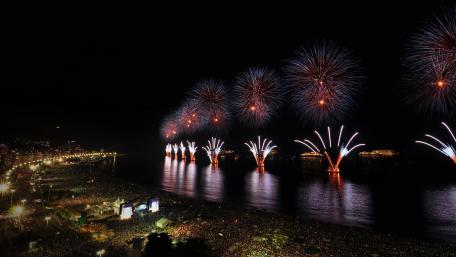 Vibrant Fireworks Over a Bustling City Night Sky wallpaper