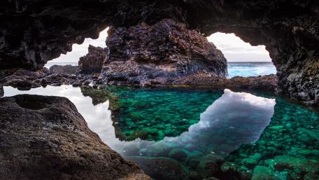 Serene Coastal Cave with Pristine Waters wallpaper