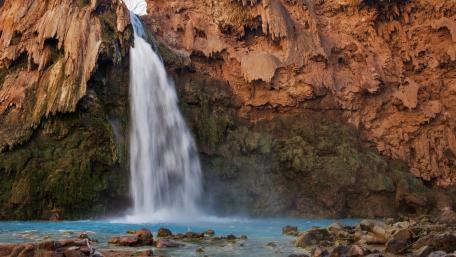 Majestic Waterfall Surrounded by Stunning Cliffs wallpaper