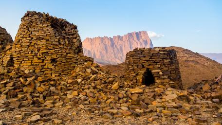 Ancient Stone Structures Amidst Majestic Mountains wallpaper
