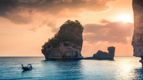 Serene Sunset Over Tranquil Waters and Rocky Formations wallpaper